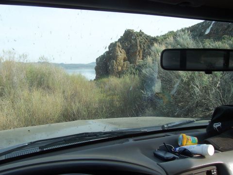 1994 Ford F-150 - Looking out from the dashboard of a vehicle at a scenic lake and rocky landscape.