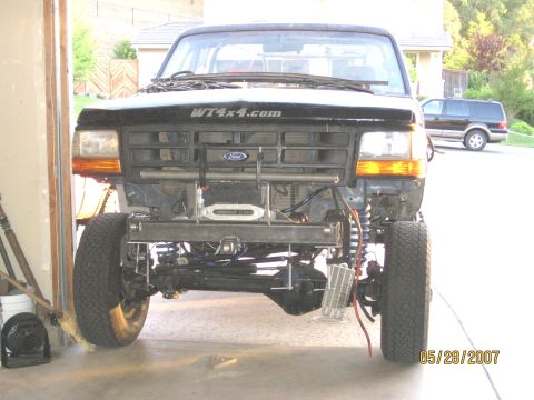 1994 Ford Bronco - Front view of a black Ford Bronco undergoing modifications, with a custom bumper and winch installed.