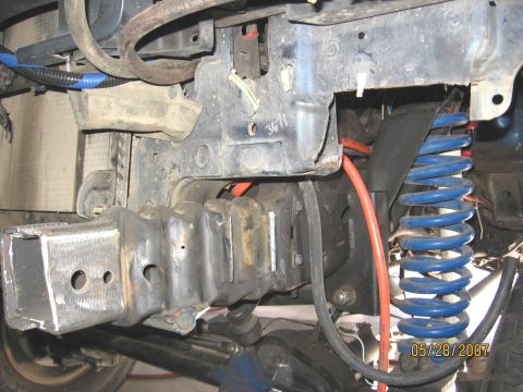 1994 Ford Bronco - Close-up view of the vehicle's front suspension and frame components, including a blue coil spring.