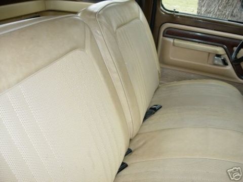 1979 Ford F-150 - The interior of a truck shows a tan bench seat and door panel with wood trim. A Supermotors logo is in the corner.