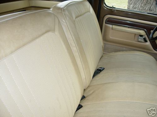 Interior shot of a truck's tan bench seat and door panel. A Supermotors logo is visible