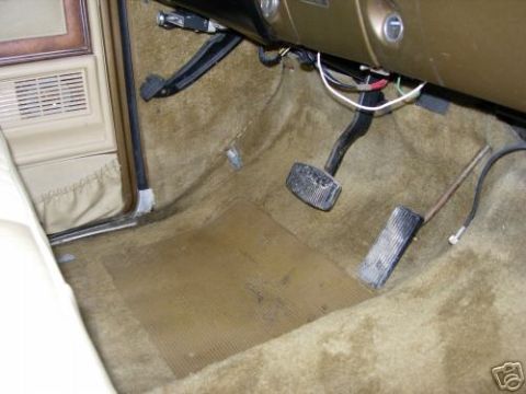 1979 Ford F-150 - Interior view of the driver's side floor, showing pedals and tan carpeting in a 1979 Ford F-150.