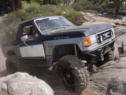 1985 Toyota Hilux - This modified Ford truck is tackling a challenging rocky trail.