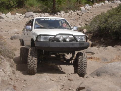 1985 Toyota Hilux - This modified Toyota pickup truck is shown off-roading on a rocky path.