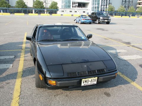 2001 Mercury Grand Marquis - A black coupe with pop-up headlights is parked in a lot with other vehicles in the background.