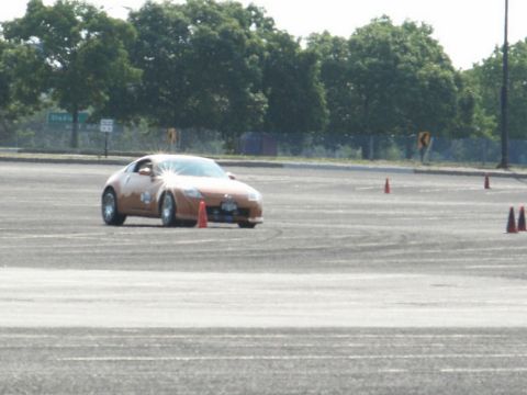 2001 Mercury Grand Marquis - Sports car driving through a cone course on a paved lot.