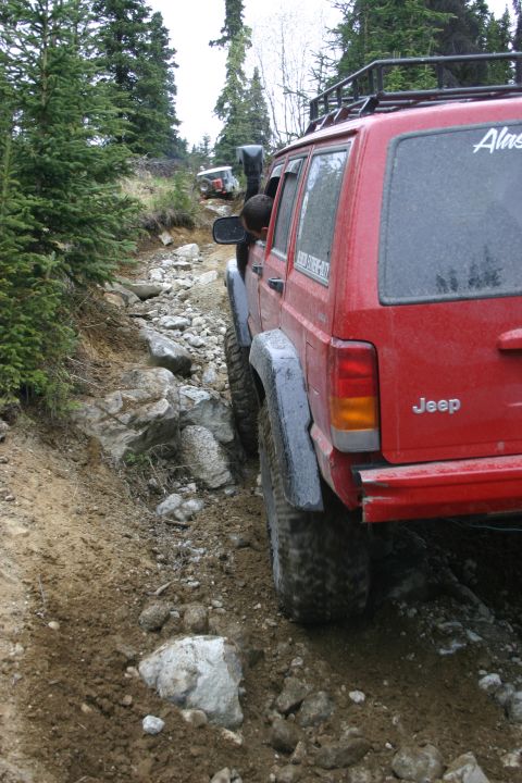 2003 Jeep TJ - Two Jeeps tackle a challenging off-road trail with steep inclines and large rocks.