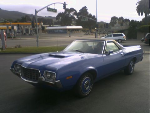 1972 Ford Ranchero - A blue 1972 Ford Ranchero is parked near a gas station and intersection.