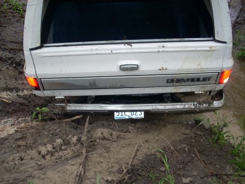 1992 Ford Bronco - This Chevrolet pickup is stuck deep in the mud, with its rear end submerged.