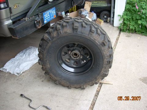 2000 Chevrolet Tahoe - A large off-road tire and wheel is shown in front of a vehicle with a "Z71" badge and a Michigan license plate.