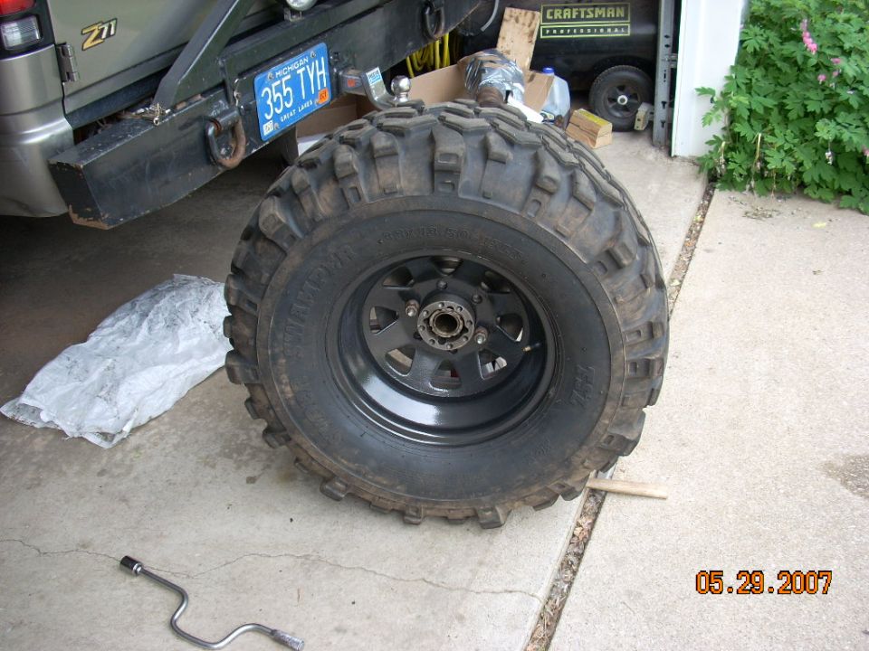 Off-road tire and wheel with a "Z71" badge visible on the vehicle in the background