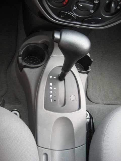 1986 Ford Bronco - Interior view of an automatic transmission shifter and center console with cup holders.