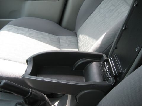 1986 Ford Bronco - The interior of a car shows an open center console armrest and gray patterned seats.