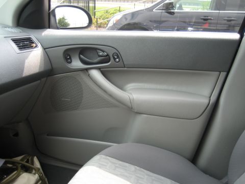 1986 Ford Bronco - Interior view of a gray door panel, showing the speaker grille and door handle.