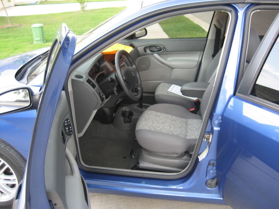 Blue car interior with open doors, showing seats and dashboard