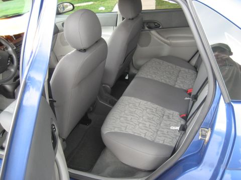 1986 Ford Bronco - Interior view of a blue car, showing the back seat and part of the front seat.