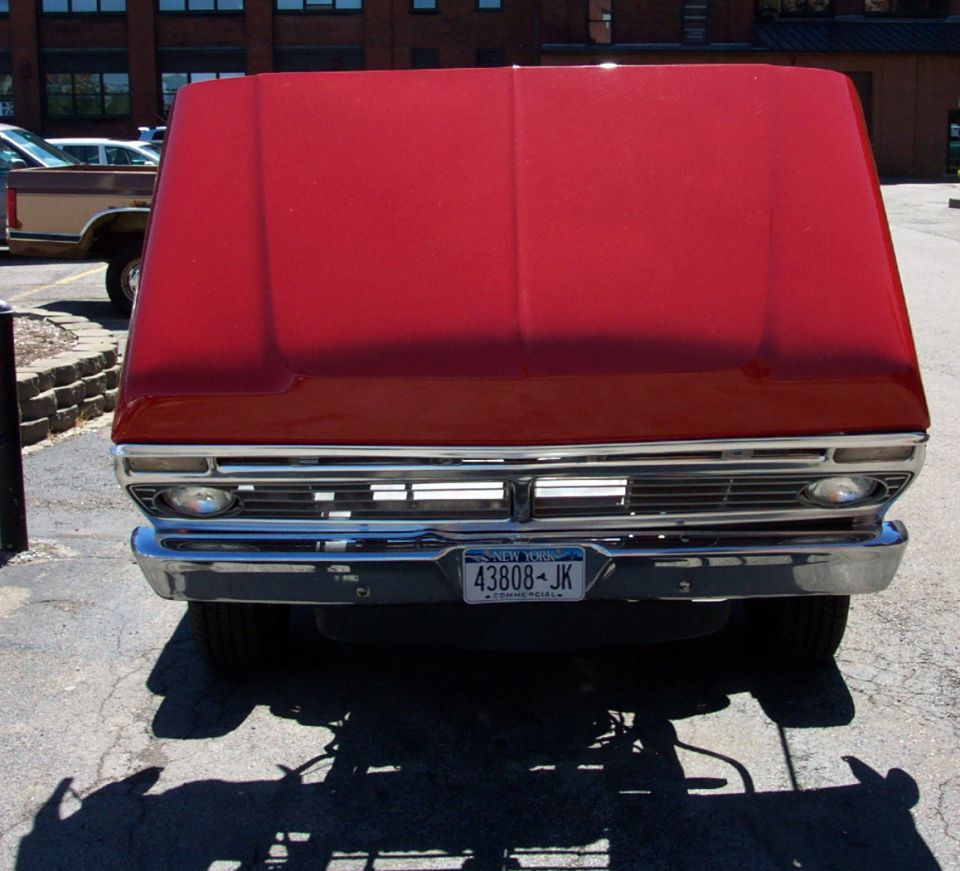 Red truck front end with chrome grille and New York license plate 43808-JK