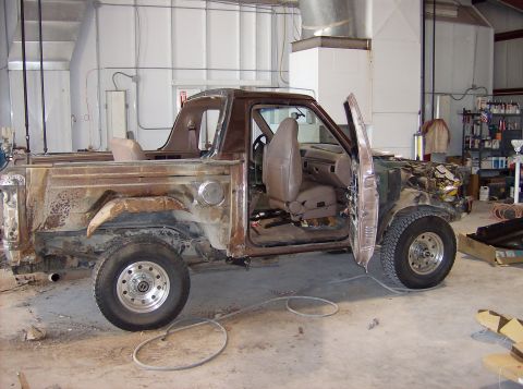 1994 Ford Bronco - This heavily rusted Ford Bronco is undergoing restoration work in a garage.