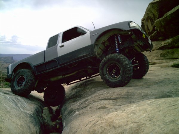 1997 Ford Ranger climbing rocks, two-tone paint, lifted suspension