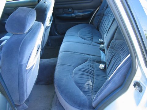 1985 Ford LTD Crown Victoria - The plush blue velour interior of a 1992 Ford Crown Victoria, showing the rear seating area.