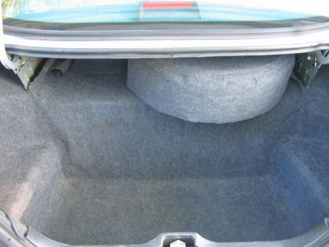 1985 Ford LTD Crown Victoria - The trunk interior shows the spare tire well and carpeted lining.