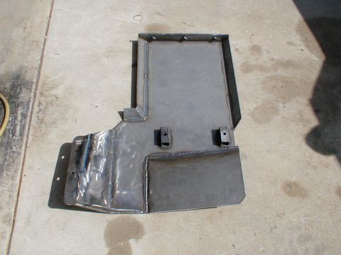 1996 Ford Bronco - A custom-fabricated metal skid plate is shown from a top-down perspective on a concrete surface.