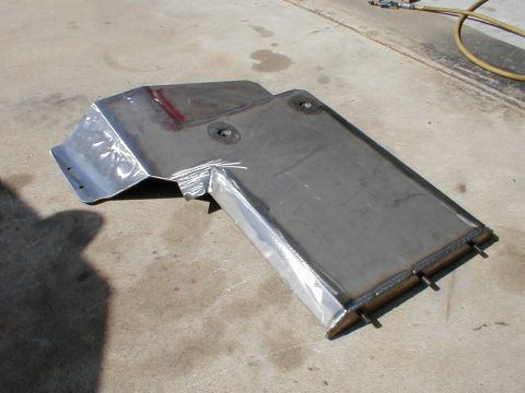 1996 Ford Bronco - A fabricated metal skid plate sits on a concrete surface, showing its construction details.