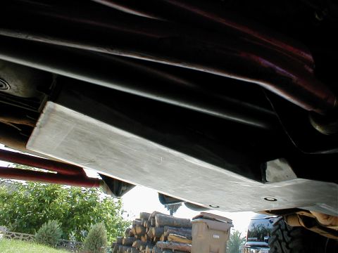 1996 Ford Bronco - A metal skid plate is mounted beneath the vehicle's frame, offering protection to underbody components.