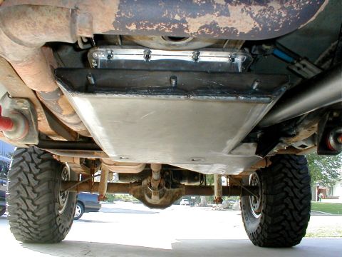 1996 Ford Bronco - The undercarriage of a modified vehicle, focusing on the transmission and transfer case skid plate.
