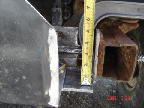 1993 Ford Bronco - Measuring a bracket on a vehicle frame with a tape measure.