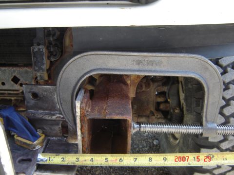 1993 Ford Bronco - A C-clamp is used to hold a rusty vehicle frame rail while a measurement is taken.