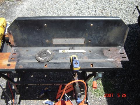 1993 Ford Bronco - A black metal part, possibly a bumper section, is shown on a workbench with various tools and clamps.