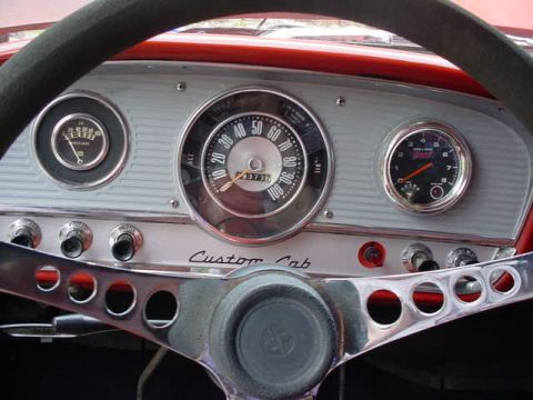 1965 Ford F-100 - The interior of a 1965 Ford F-100 shows its "Custom Cab" dashboard with various gauges and a distinctive steering wheel.