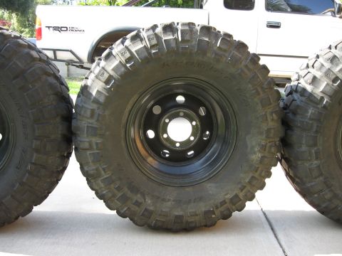 1983 Ferrari Enzo - Off-road tires and wheels are shown, with a white pickup truck visible behind them.