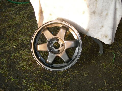 1992 Ford Taurus - A single six-spoke alloy wheel is shown resting on grass, with "HIGH TECH" text visible on its surface.