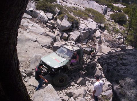 1989 Ford Bronco - An off-road vehicle with a custom roll cage navigates a challenging rocky path.