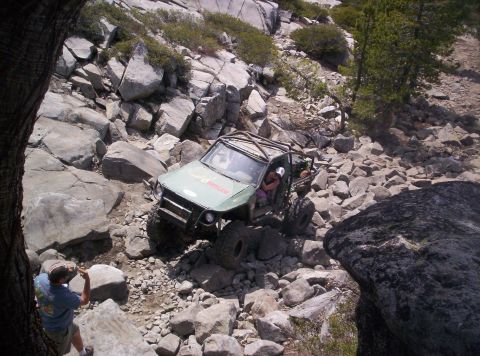 1989 Ford Bronco - A modified off-road vehicle tackles a challenging, boulder-strewn path.