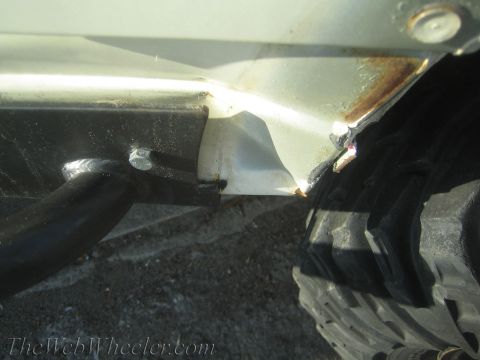 1987 Suzuki Samurai - Close-up of a vehicle's rocker panel and tire tread, showing signs of rust.
