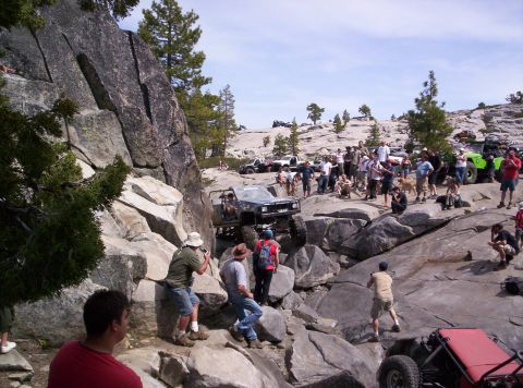 1989 Ford Bronco - Off-road vehicles navigate a rocky terrain with spectators observing the action.