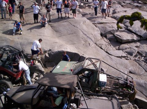 1989 Ford Bronco - Spectators watch as off-road vehicles navigate a challenging rocky course.