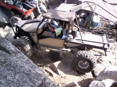 1989 Ford Bronco - Two off-road vehicles are shown navigating a challenging rocky trail.