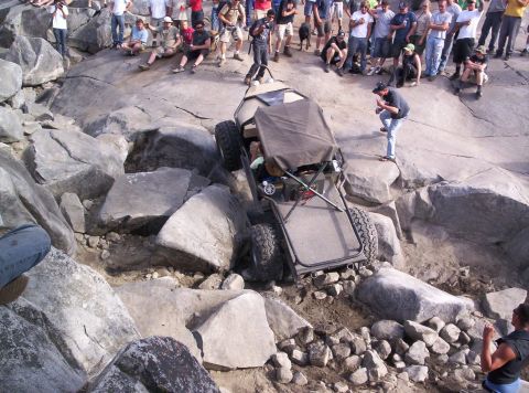 1989 Ford Bronco - A crowd watches as an off-road buggy navigates a challenging rocky terrain.