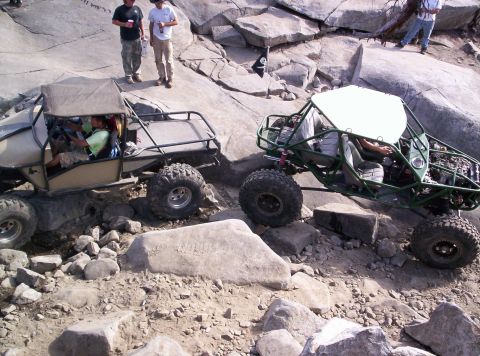 1989 Ford Bronco - Two custom off-road buggies tackle a challenging rocky course, demonstrating their off-road capabilities.