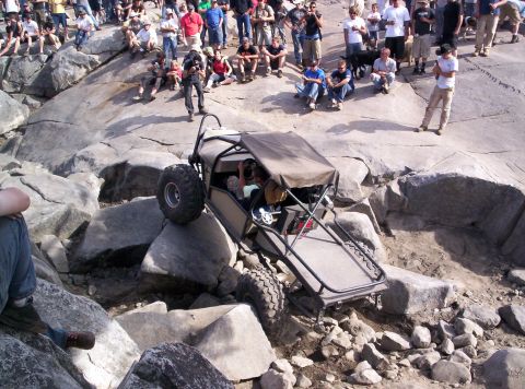 1989 Ford Bronco - Spectators watch an off-road buggy tackle a challenging rocky terrain.