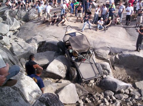 1989 Ford Bronco - Spectators gather to watch an off-road vehicle navigate a challenging rocky terrain.