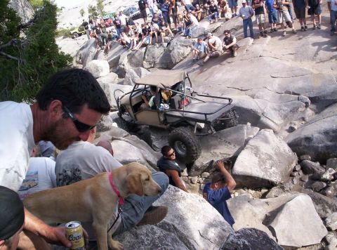 1989 Ford Bronco - An off-road buggy navigates a rocky terrain while a crowd watches from above.