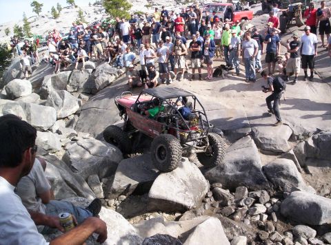 1989 Ford Bronco - Spectators watch an off-road buggy navigate a challenging rocky terrain.