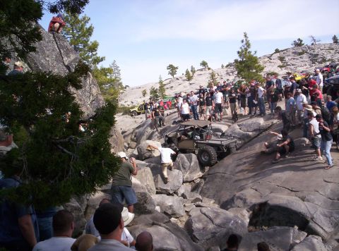 1989 Ford Bronco - Spectators gather to watch off-road vehicles tackle a challenging rocky course.