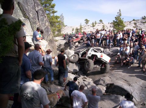 1989 Ford Bronco - Spectators gather to watch off-road vehicles navigate a challenging rocky terrain.