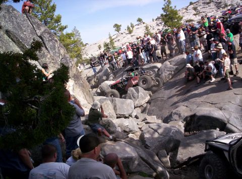 1989 Ford Bronco - A crowd watches as off-road vehicles tackle a challenging rocky course.